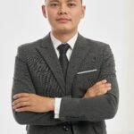 Portrait of a confident businessman in a formal suit with arms crossed, isolated on white background.